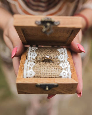 Personalized rustic wedding ring box with wooden texture and metal hardware, adding elegance and charm to the wedding ceremony.