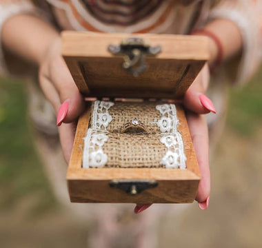 Personalized rustic wedding ring box with wooden texture and metal hardware, adding elegance and charm to the wedding ceremony.